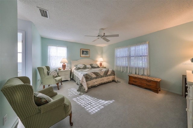 bedroom featuring ceiling fan, carpet, and a textured ceiling