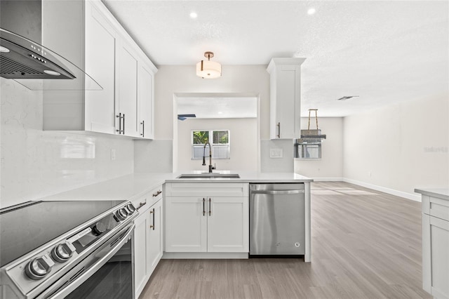 kitchen with light hardwood / wood-style floors, sink, white cabinetry, and stainless steel appliances