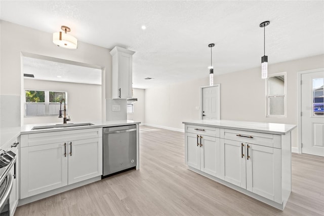 kitchen featuring appliances with stainless steel finishes, light wood-type flooring, white cabinetry, and sink