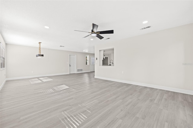 unfurnished living room featuring ceiling fan and light wood-type flooring