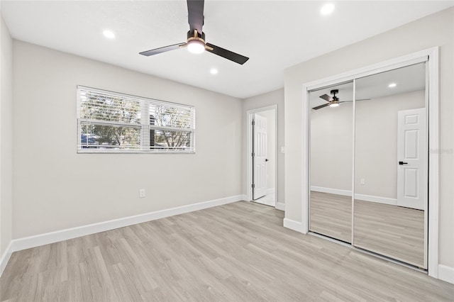 unfurnished bedroom featuring ceiling fan, a closet, and light wood-type flooring