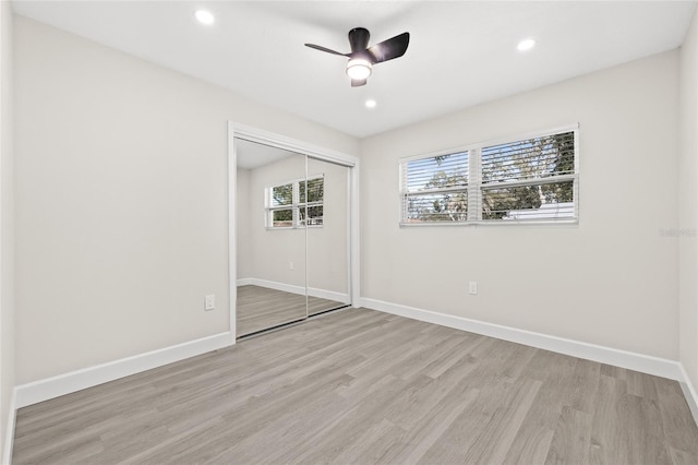 unfurnished bedroom with ceiling fan, a closet, and light hardwood / wood-style flooring