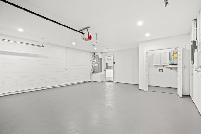 garage featuring a garage door opener and heating unit