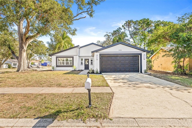 ranch-style home featuring a garage and a front lawn