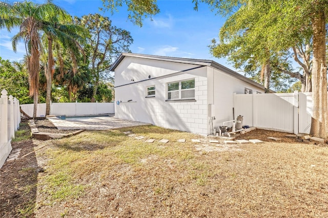 rear view of house with a lawn and a patio area