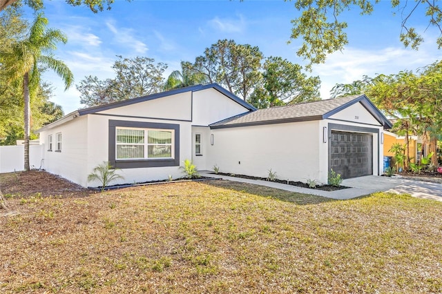 single story home with a garage and a front lawn