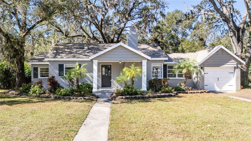 view of front of property featuring a garage and a front lawn