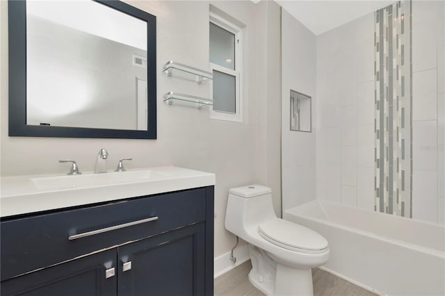 full bathroom with tiled shower / bath, vanity, wood-type flooring, and toilet