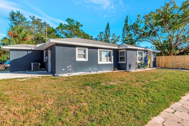 view of front of house with a front yard and central AC