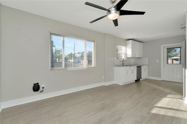 unfurnished living room with a wealth of natural light, light hardwood / wood-style flooring, ceiling fan, and sink