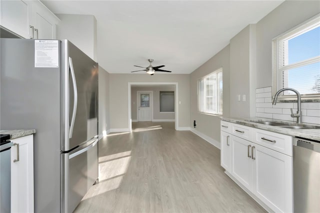 kitchen featuring white cabinetry, sink, stainless steel appliances, and plenty of natural light