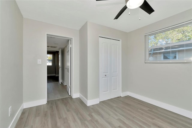 unfurnished bedroom featuring a closet, light hardwood / wood-style flooring, and ceiling fan