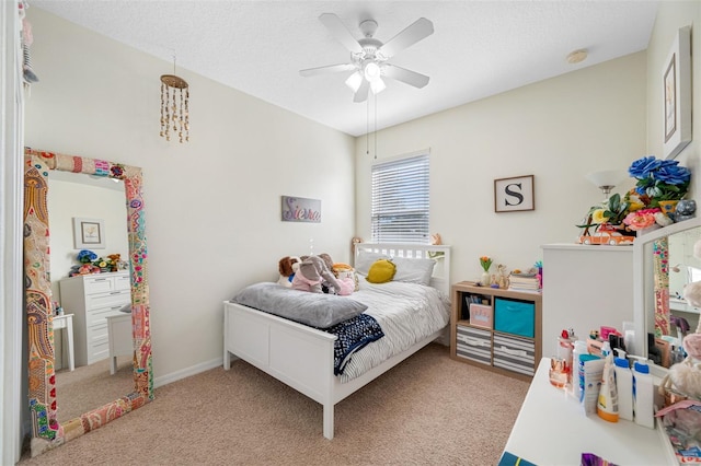 carpeted bedroom with ceiling fan and a textured ceiling