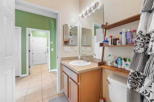 bathroom featuring tile patterned flooring, vanity, and toilet