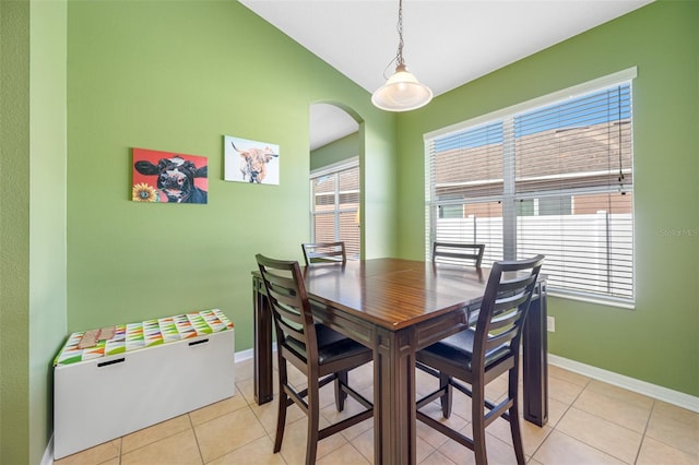 dining space featuring light tile patterned floors and vaulted ceiling