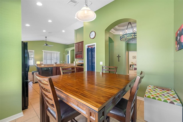 tiled dining room with ceiling fan, sink, lofted ceiling, and ornamental molding