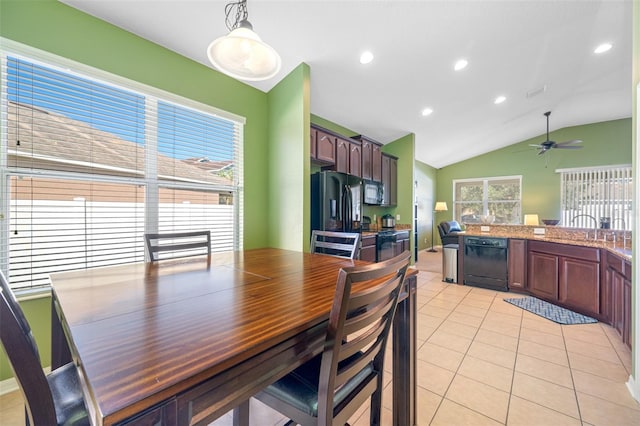 tiled dining space with ceiling fan, lofted ceiling, and sink