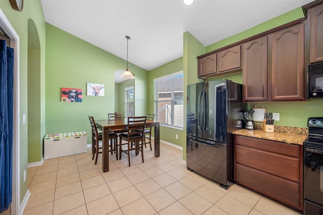 kitchen featuring black appliances, vaulted ceiling, light stone countertops, decorative light fixtures, and dark brown cabinetry