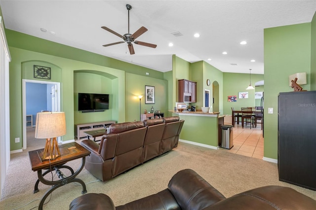 living room featuring a textured ceiling, ceiling fan, and light carpet