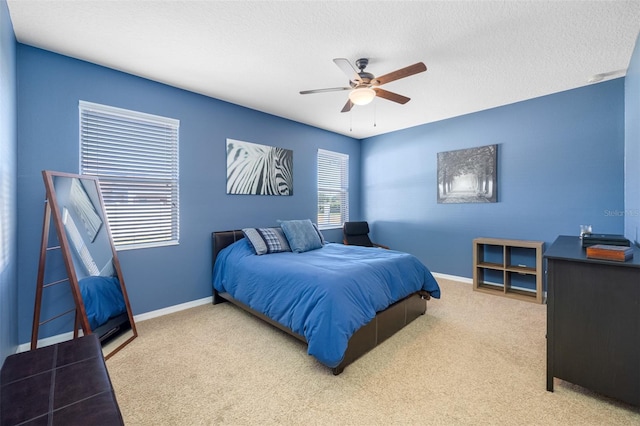 carpeted bedroom featuring a textured ceiling and ceiling fan