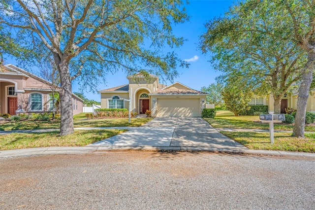 mediterranean / spanish-style house featuring a front lawn and a garage