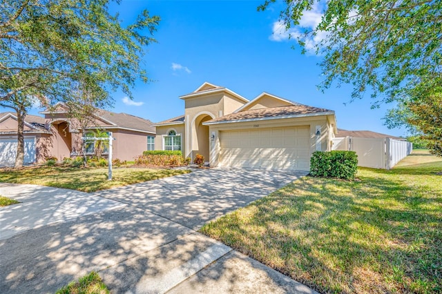 mediterranean / spanish house with a garage and a front lawn