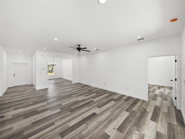 unfurnished living room with ceiling fan and dark hardwood / wood-style flooring