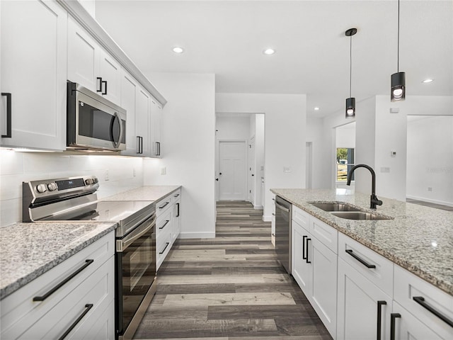 kitchen with sink, white cabinets, pendant lighting, and stainless steel appliances