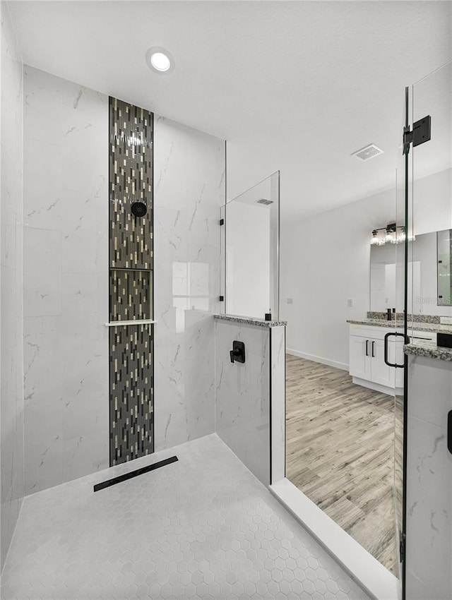 bathroom featuring a tile shower and vanity