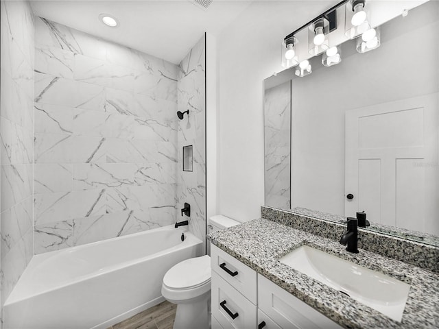 full bathroom with wood-type flooring, tiled shower / bath combo, vanity, and toilet