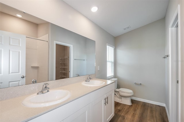 full bathroom with toilet, wood finished floors, a sink, and visible vents