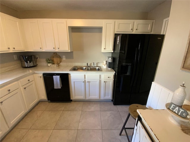 kitchen featuring black appliances, white cabinetry, sink, and light tile patterned floors