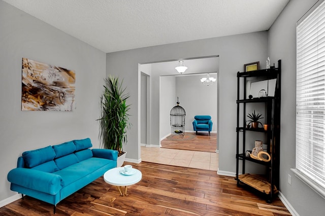 sitting room with a chandelier, wood-type flooring, and a textured ceiling