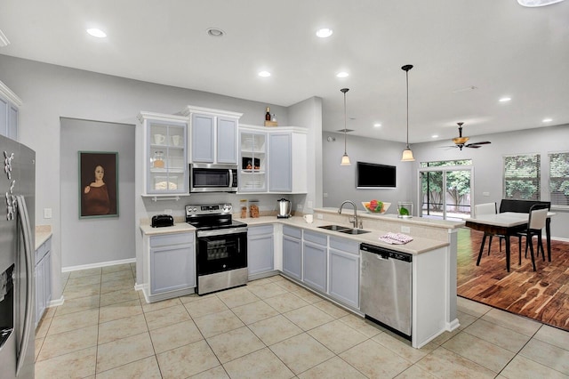 kitchen featuring white cabinetry, ceiling fan, sink, kitchen peninsula, and appliances with stainless steel finishes