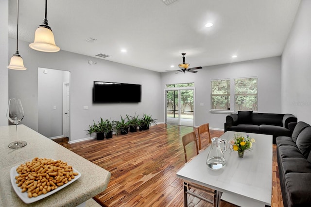 living room with wood-type flooring and ceiling fan