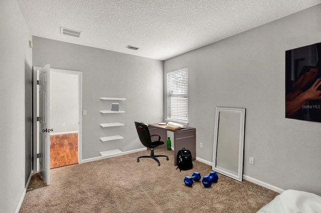 carpeted office with a textured ceiling