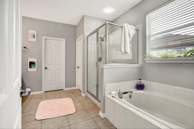 bathroom featuring plenty of natural light, plus walk in shower, a textured ceiling, and tile patterned flooring