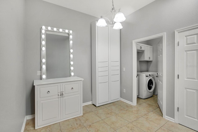 laundry area featuring an inviting chandelier, light tile patterned floors, and washing machine and clothes dryer