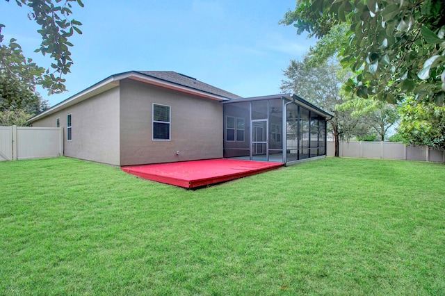 back of house with a sunroom, a yard, and a deck