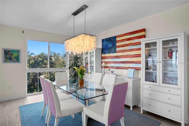 dining space with light hardwood / wood-style flooring and a chandelier