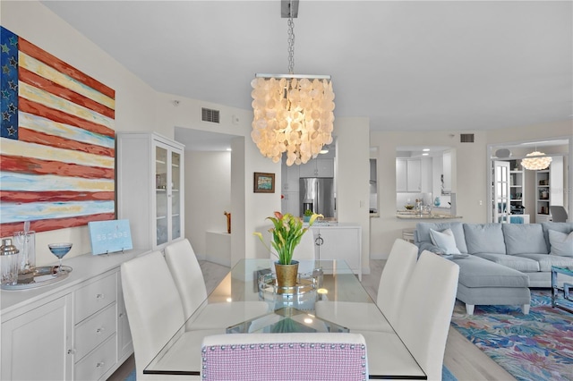 dining area with a chandelier and light hardwood / wood-style flooring