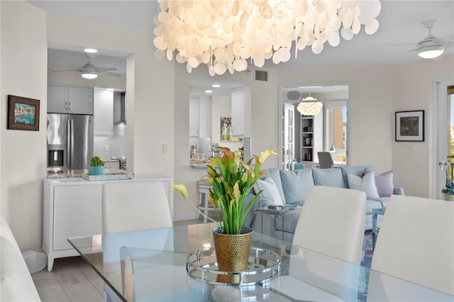 dining area with light wood-type flooring and ceiling fan