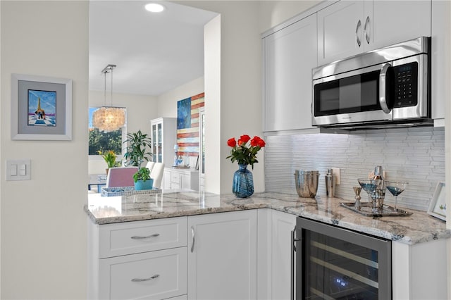 kitchen featuring white cabinets, light stone countertops, tasteful backsplash, and beverage cooler