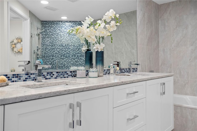 bathroom featuring plus walk in shower, vanity, and tile walls