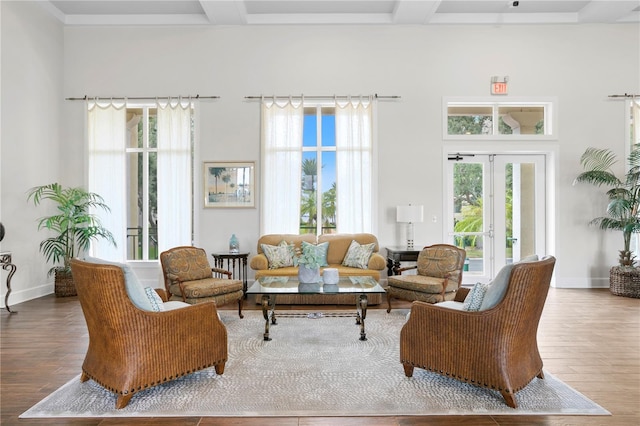 living room with hardwood / wood-style flooring, beamed ceiling, and french doors