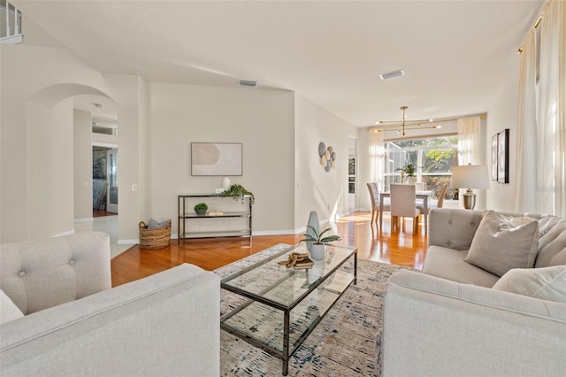 living room with wood-type flooring and an inviting chandelier