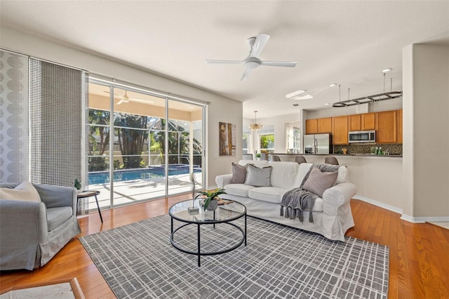 living room featuring ceiling fan and light hardwood / wood-style flooring