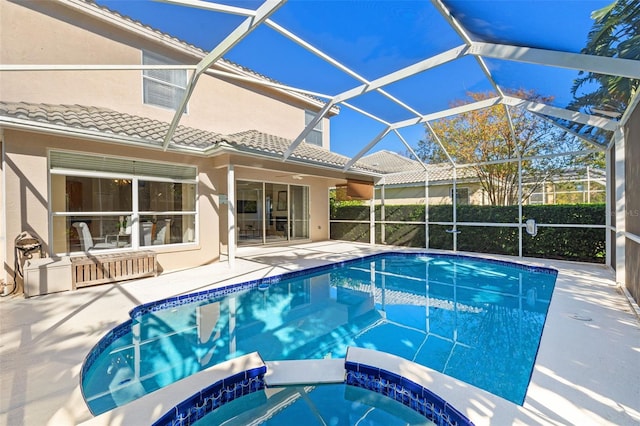 view of swimming pool featuring glass enclosure, ceiling fan, an in ground hot tub, and a patio