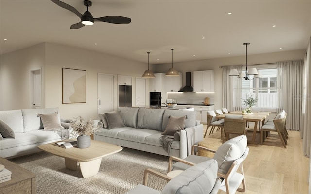 living room with ceiling fan with notable chandelier and light hardwood / wood-style floors