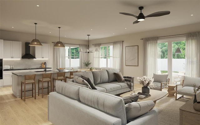 living room featuring light hardwood / wood-style floors, ceiling fan, and sink